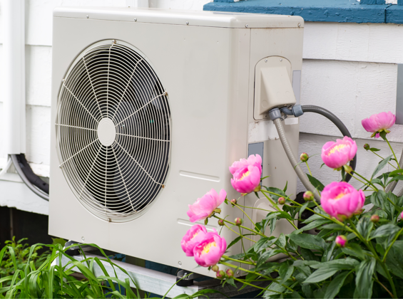 air source heat pump next to flowers in the garden